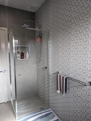 a shower stall in a bathroom with a tile wall at Immaculate 2-Beds Entire House Chermside Brisbane in Brisbane