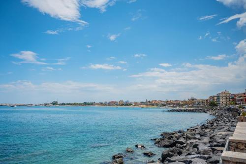 a view of a beach with rocks in the water at Naxos Marina Bay in Giardini Naxos
