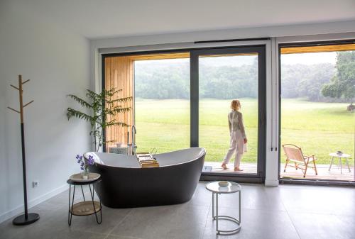 a woman walking into a bathroom with a bath tub at VIBE LUXURY CABINS in Arnuero
