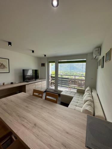 uma sala de estar com uma mesa e um sofá em BovecEnter Apartments Kaninska vas em Bovec