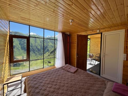 a bedroom with a bed and a large window at Ardoti Guest House in Ardoti