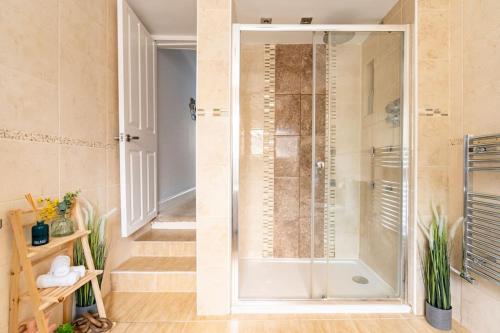 a shower with a glass door in a bathroom at Gorgeous Beach House in Kent