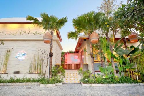 una casa con palmeras delante en La Vie Villa Seminyak by Ini Vie Hospitality, en Legian