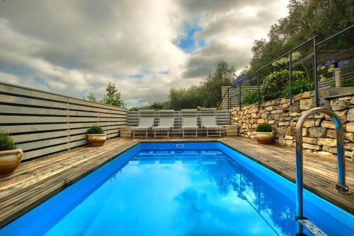 una piscina con sillas y una pared de piedra en Chalet in Liguria, en Vasia