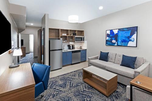 a living room with a couch and a kitchen at Candlewood Suites DFW Airport North - Irving by IHG in Irving