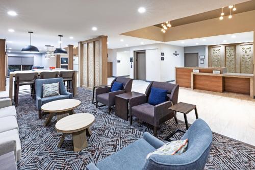 een wachtkamer met stoelen en tafels en een bar bij Candlewood Suites DFW Airport North - Irving, an IHG Hotel in Irving