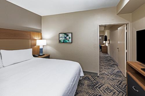 a hotel room with a bed and a flat screen tv at Candlewood Suites DFW Airport North - Irving by IHG in Irving