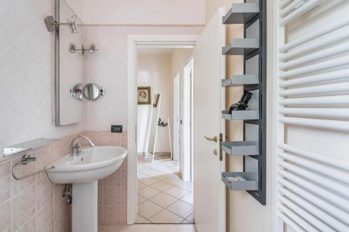 a bathroom with a sink and a toilet and a shelf at A due passi da Borgo San Giuliano Apartment in Rimini