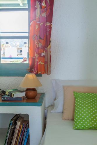 a bedroom with a bed and a table with a lamp at Sea view _ Cycladic Style House _ Steps to Sea in Sissi