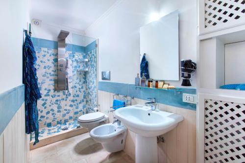 un bagno blu e bianco con lavandino e servizi igienici di Faraglionensis MonaconeHouse Apartment a Capri