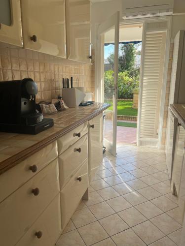 une cuisine avec des placards blancs et une porte donnant sur une cour. dans l'établissement 2 pièces, 4 couchages terrasse, garage, à Cannes