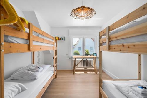 a room with two bunk beds and a table at Villa Maria Villa aan zee met privé parking 8p in Nieuwpoort