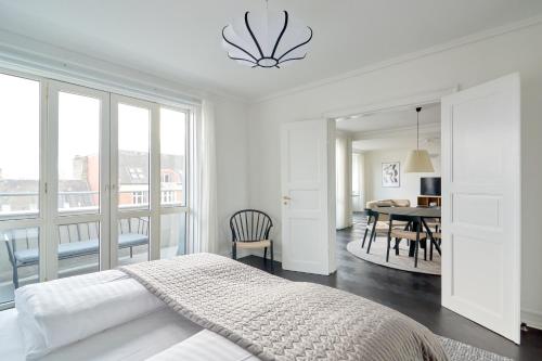 a white bedroom with a bed and a dining room at Beautiful 3 Bedroom Flat Near Shopping & Metro in Copenhagen
