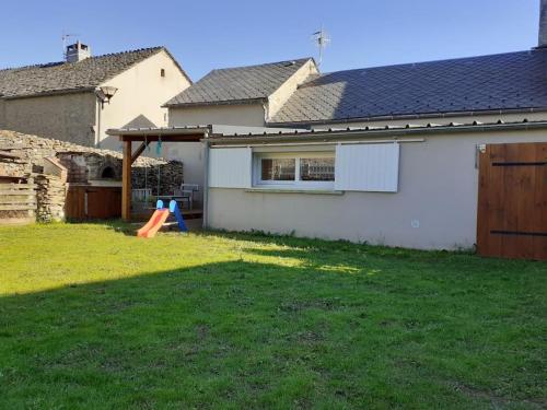 a yard with a house and a playground at La cabane au fond du jardin in Montrodat
