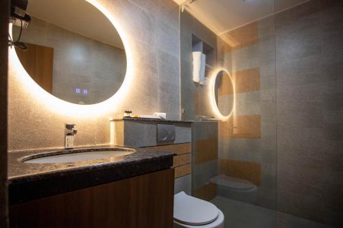 La salle de bains est pourvue d'un lavabo, de toilettes et d'un miroir. dans l'établissement Nansc Hotel, à Siddharthanagar