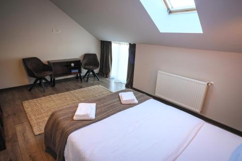 Schlafzimmer mit einem Bett, einem Schreibtisch und Stühlen in der Unterkunft Popa Apartment in Cluj-Napoca