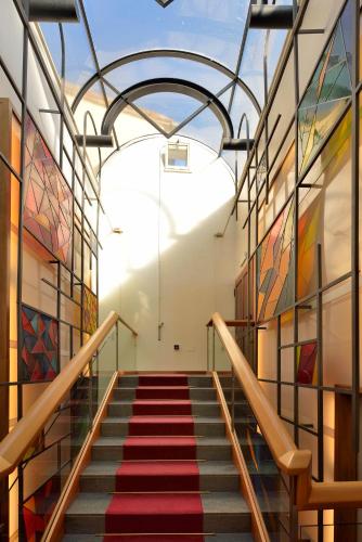a staircase in a building with colorful paintings on the walls at Hotel Fonte Cesia in Todi