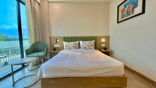 a bedroom with a bed and a large window at Hotel Limon & Banquet Sector 29, Gurgaon in Gurgaon