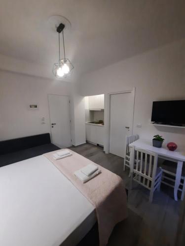 - une chambre avec un lit, une table et une télévision dans l'établissement Nora's Guesthouse, à Saranda
