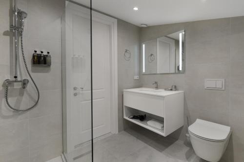 a bathroom with a shower and a toilet and a sink at Boulevard Hotel Batumi in Batumi