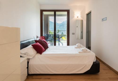 a bedroom with a large bed and a balcony at Casa Penny - Menaggio in Menaggio