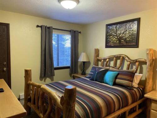 a bedroom with a wooden bed and a window at Giant Steps 63 Ski In-out in Brian Head