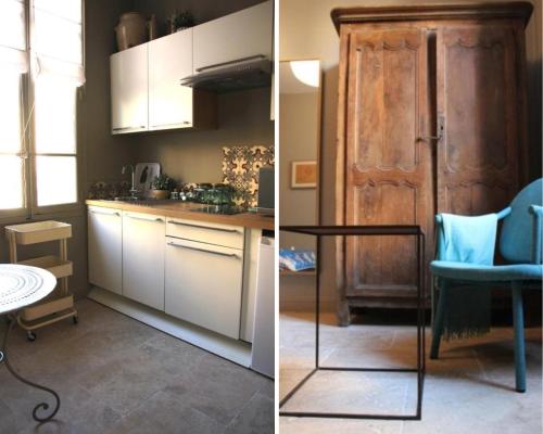 a kitchen with white cabinets and a blue chair and a table at Les Cachettes in Avignon