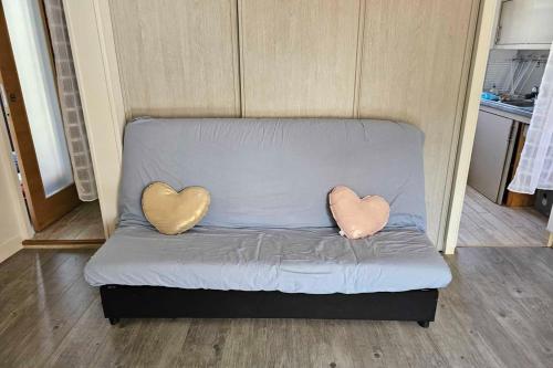 two heart shaped pillows on a couch in a room at Renovated apartment near the beach in Villers-sur-Mer