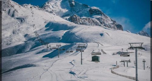 a ski lift in front of a snow covered mountain at Mestia Roots in Mestia