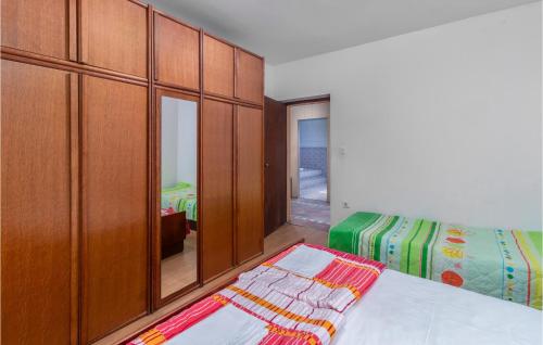 um quarto com uma cama e um armário de madeira em Gorgeous Apartment In Lopar With Wifi em Lopar