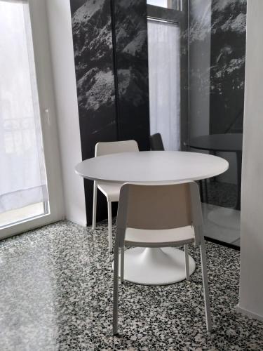 a white table and two chairs in a room at Mandello amorevole dimora in Lecco in Lecco