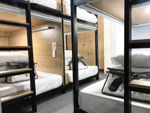 a room with four bunk beds and a mirror at Amango Dorm in Ho Chi Minh City