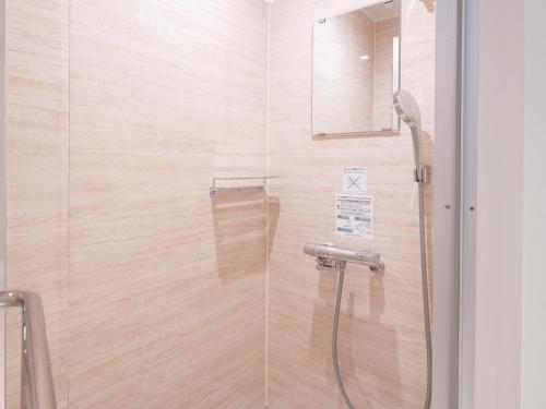 a bathroom with a shower with a glass door at REF Okinawa Arena by VESSEL HOTELS in Okinawa City
