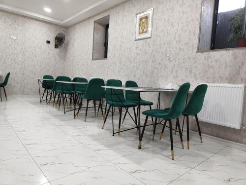 a conference room with green chairs and a table at Hotel Sevinch in Tashkent