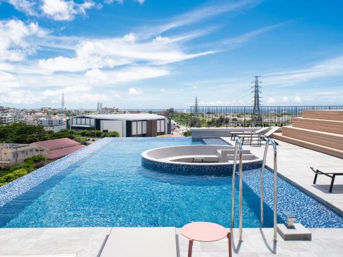 a swimming pool on the roof of a building at REF Okinawa Arena by VESSEL HOTELS in Okinawa City
