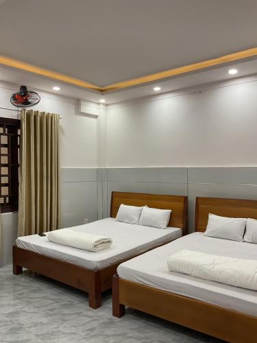 two beds sitting next to each other in a room at Hoàng Linh Hotel in Buon Ma Thuot