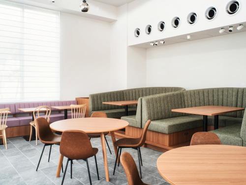 a restaurant with tables and chairs and couches at REF Okinawa Arena by VESSEL HOTELS in Okinawa City