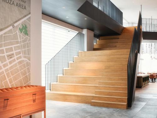 a staircase in a building with wooden steps at REF Okinawa Arena by VESSEL HOTELS in Okinawa City