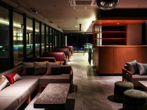 a waiting room with couches and a bar at REF Okinawa Arena by VESSEL HOTELS in Okinawa City