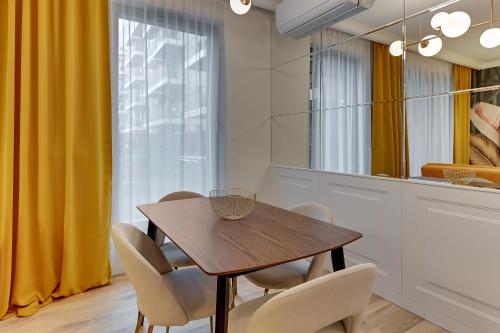 a dining room with a wooden table and chairs at GRANO APARTMENTS Gdańsk Old Town SPA & Wellness - GRANO APARTMENTS Gdańsk Residence SPA & Wellness in Gdańsk