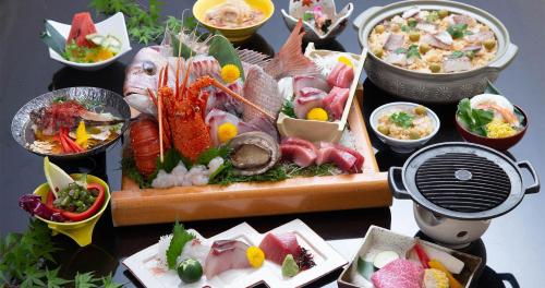 a table topped with lots of different types of food at Tenku Hotel Kairo in Tonosho