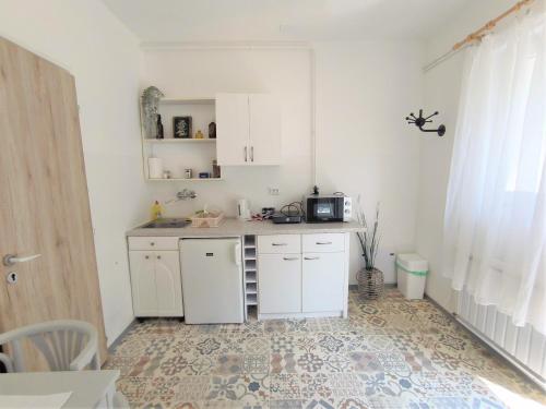 a small kitchen with white cabinets and a microwave at Caesar Residence in Budapest