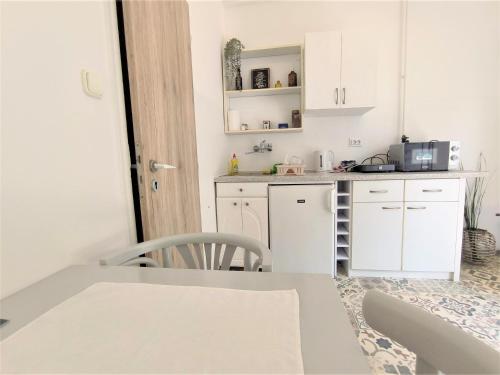 a small kitchen with white cabinets and a table at Caesar Residence in Budapest