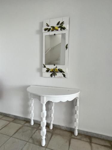 a white dressing table with a mirror on a wall at Hotel Anezina in Drios