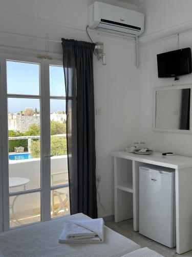 a bedroom with a window with a view of a balcony at Hotel Anezina in Drios