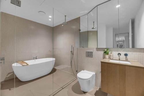 a bathroom with a tub and a toilet and a sink at Luxe Panoramic 3 Bedroom Penthouse with onsite parking in Melbourne
