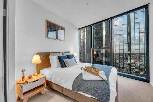 a bedroom with a bed and a large window at Luxe Panoramic 3 Bedroom Penthouse with onsite parking in Melbourne