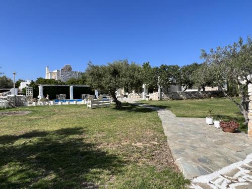 a park with a bench and trees in the grass at Hotel Anezina in Drios