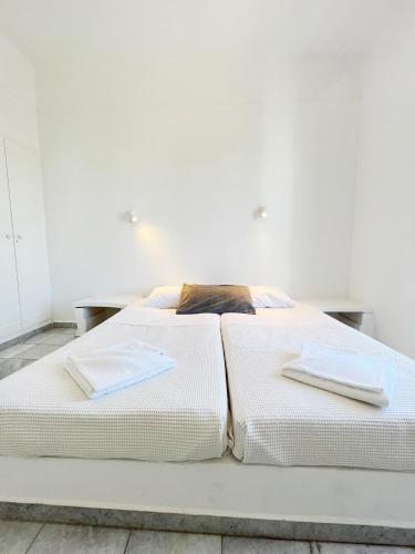 a white bed with two pillows on top of it at Hotel Anezina in Drios