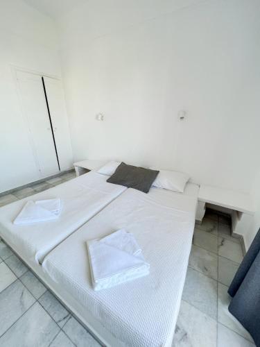 a white bed with two towels on it in a room at Hotel Anezina in Drios